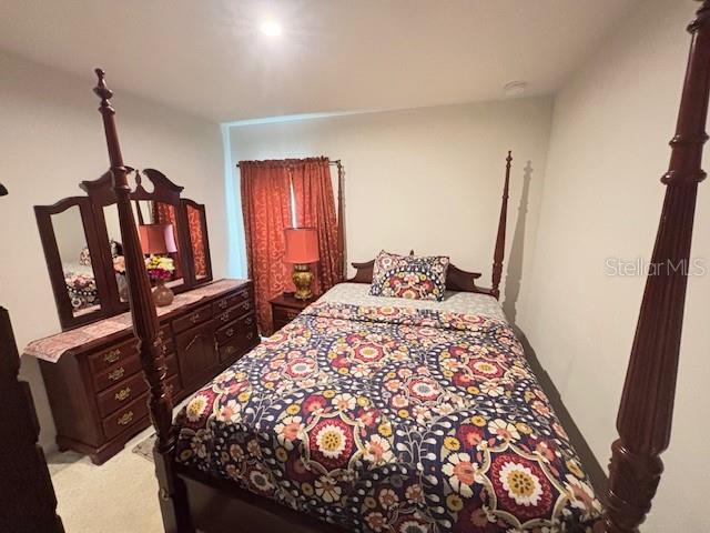 bedroom featuring light colored carpet