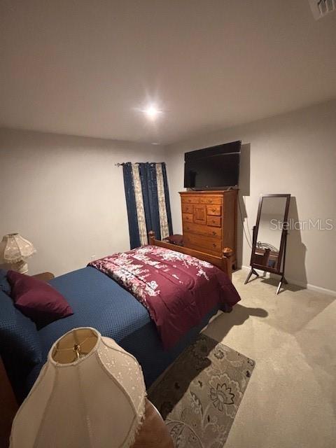 bedroom with carpet floors, visible vents, and baseboards