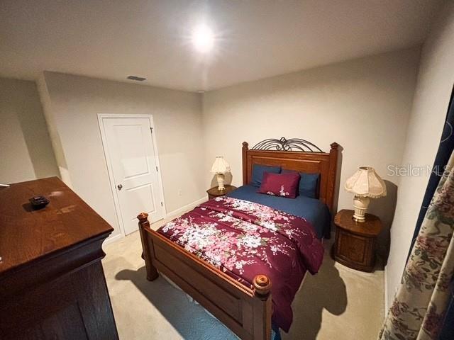 carpeted bedroom featuring visible vents