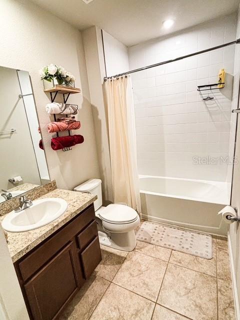 full bathroom with toilet, tile patterned floors, shower / bath combo, and vanity