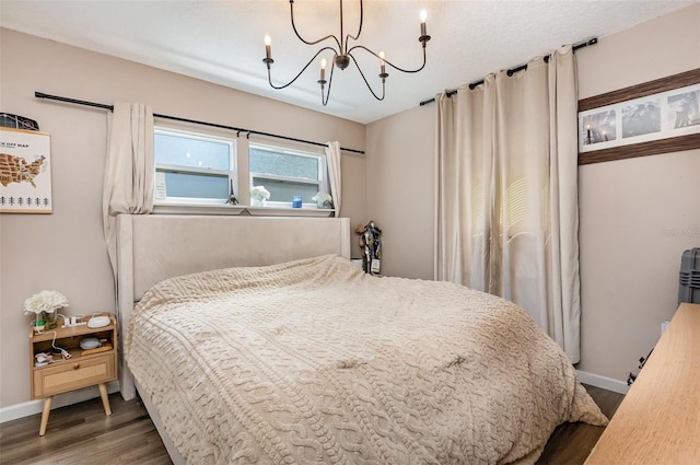 bedroom featuring baseboards, an inviting chandelier, and wood finished floors