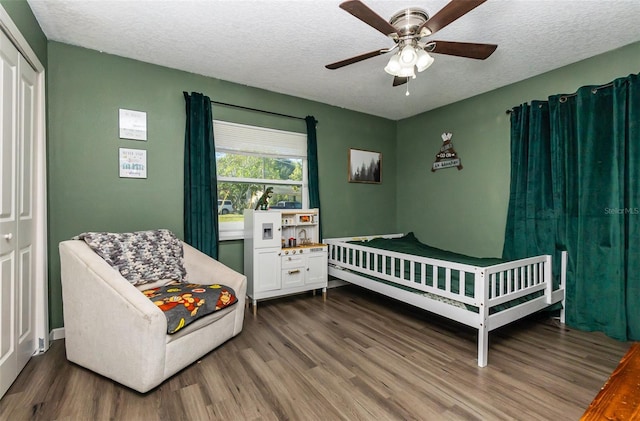 bedroom featuring a textured ceiling, wood finished floors, and a ceiling fan