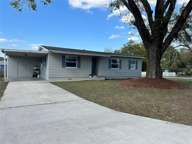 ranch-style house featuring an attached carport, driveway, and a front yard