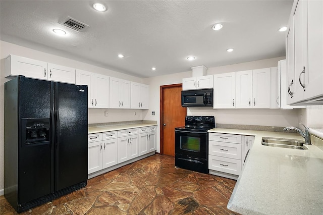 kitchen featuring black appliances, a sink, visible vents, and white cabinetry