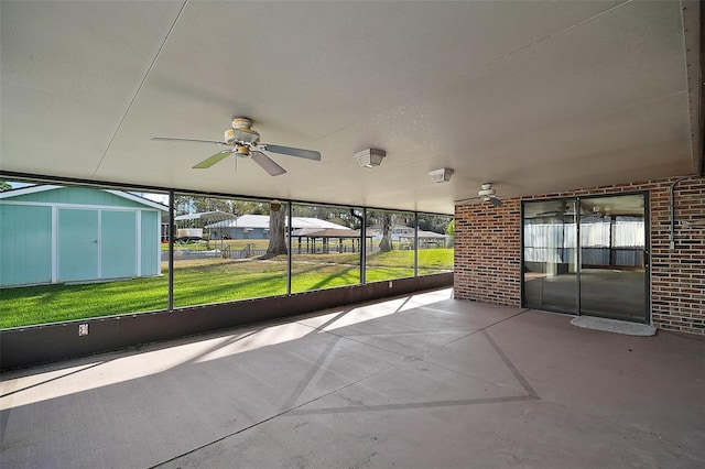 unfurnished sunroom featuring a ceiling fan