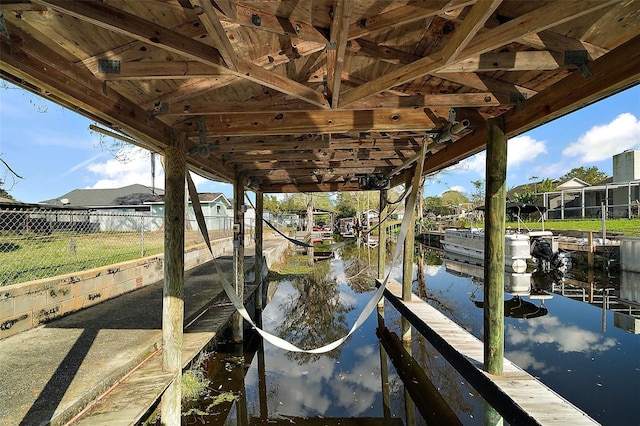 view of dock with a water view and fence