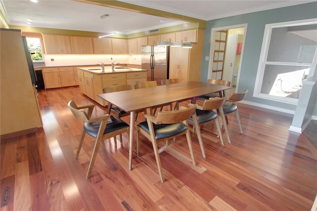 dining area with visible vents, ornamental molding, light wood-style flooring, and baseboards