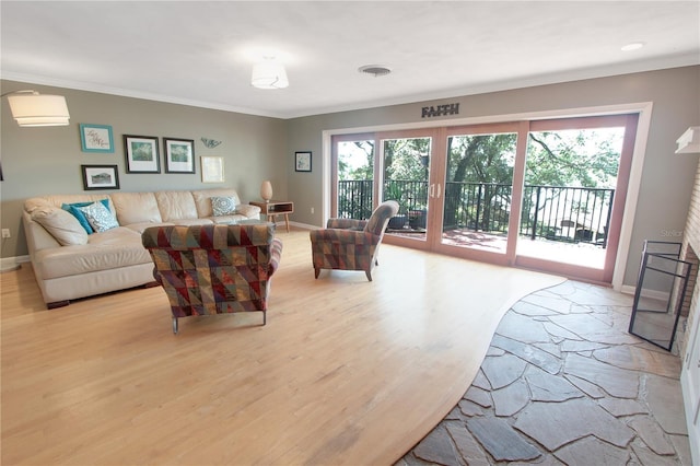 living room with crown molding, light wood-style flooring, and baseboards