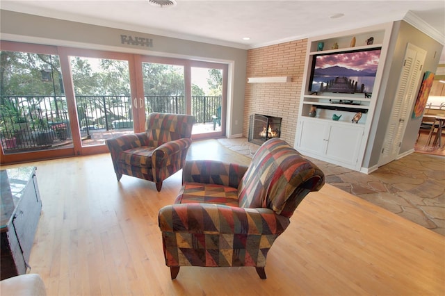 living room with built in shelves, a fireplace, baseboards, light wood-style floors, and crown molding