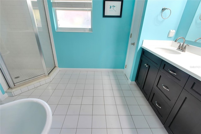 bathroom featuring tile patterned flooring, vanity, baseboards, a soaking tub, and a shower stall