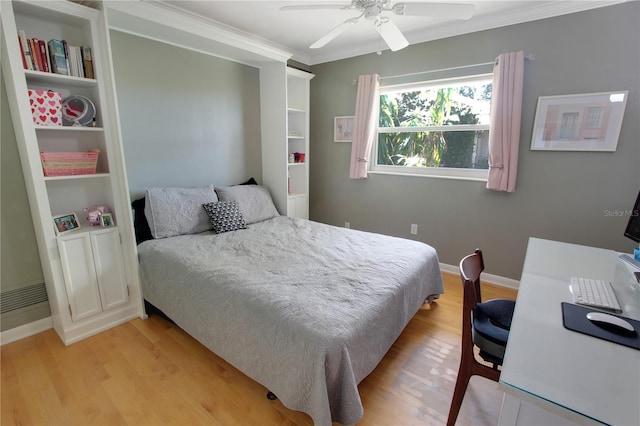 bedroom with ornamental molding, baseboards, light wood finished floors, and a ceiling fan