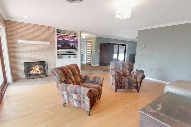 living room with baseboards, ornamental molding, light wood-type flooring, and a brick fireplace