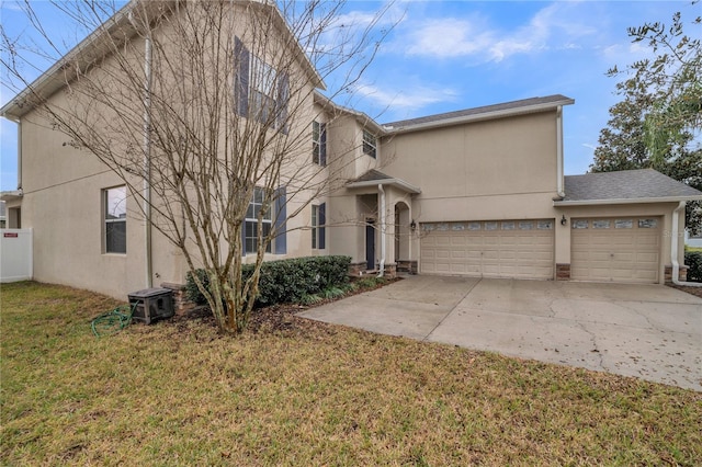 view of front of house featuring an attached garage, concrete driveway, a front yard, and stucco siding