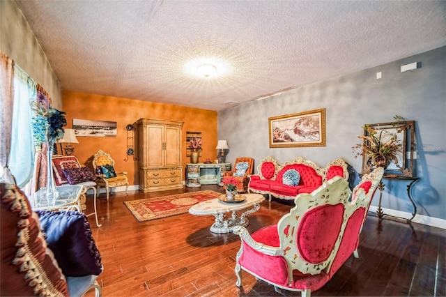 living room with a textured ceiling, wood finished floors, and baseboards