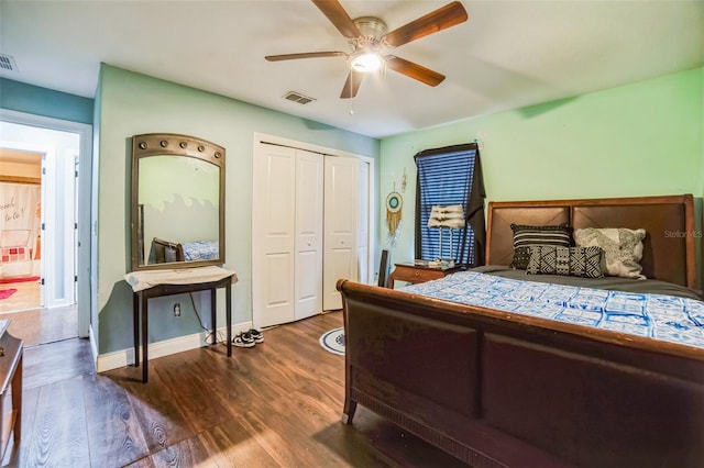 bedroom featuring dark wood-style floors, a closet, visible vents, and baseboards