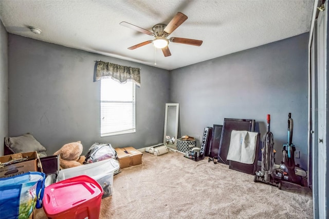 game room featuring a textured ceiling, carpet, and a ceiling fan