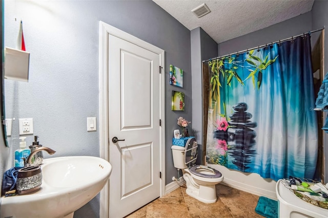 full bathroom with baseboards, visible vents, toilet, a textured ceiling, and a sink