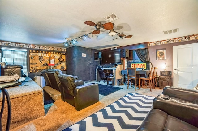 living room with a textured ceiling, carpet, and visible vents