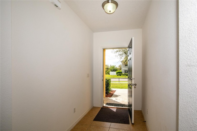 doorway to outside with baseboards and light tile patterned floors