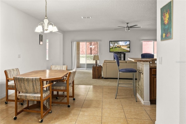 dining area featuring a textured ceiling, ceiling fan with notable chandelier, light tile patterned flooring, and visible vents