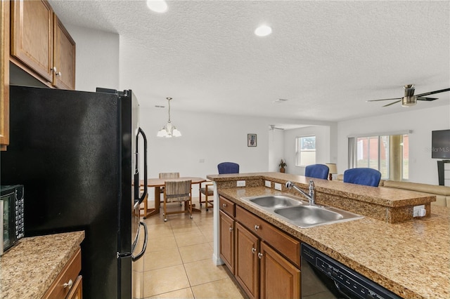 kitchen featuring brown cabinets, a breakfast bar area, light tile patterned flooring, a sink, and black appliances