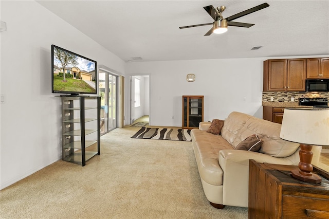 living area with a ceiling fan, visible vents, light carpet, and baseboards