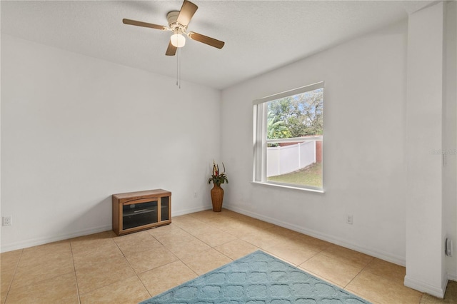 empty room featuring baseboards, a textured ceiling, and tile patterned floors