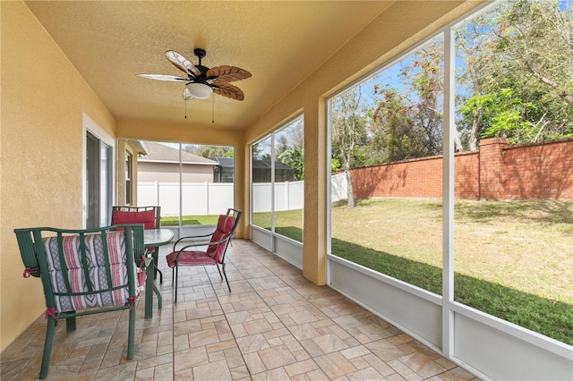 sunroom / solarium featuring a ceiling fan