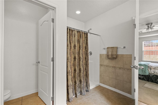 ensuite bathroom with a ceiling fan, toilet, ensuite bath, curtained shower, and tile patterned flooring