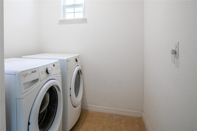 washroom with laundry area, washer and clothes dryer, light tile patterned flooring, and baseboards