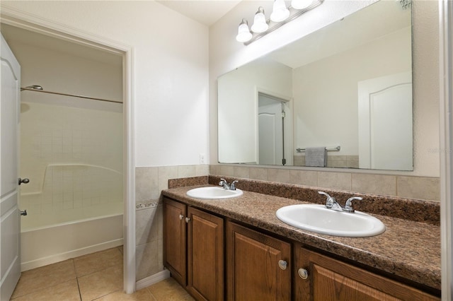 full bathroom featuring double vanity, tile patterned flooring, a sink, and tile walls