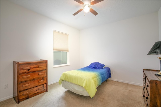 bedroom with a ceiling fan, light colored carpet, and baseboards