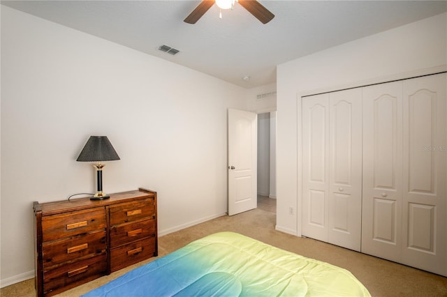 bedroom featuring baseboards, a closet, visible vents, and light colored carpet