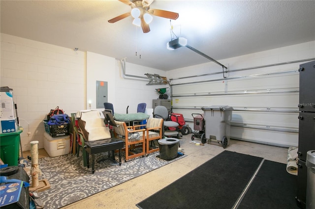 garage featuring a ceiling fan, electric panel, concrete block wall, and a garage door opener