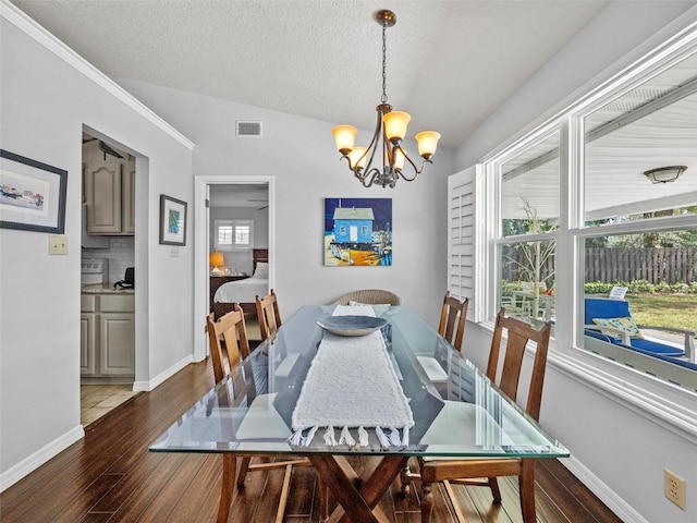 dining area with a chandelier, visible vents, baseboards, and wood finished floors