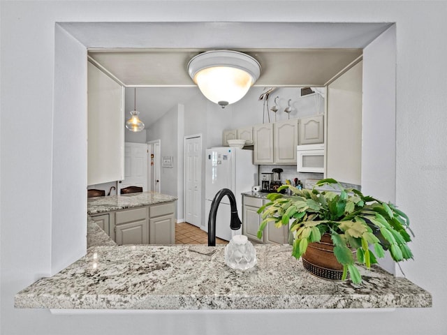 kitchen featuring a peninsula, white appliances, a sink, and visible vents