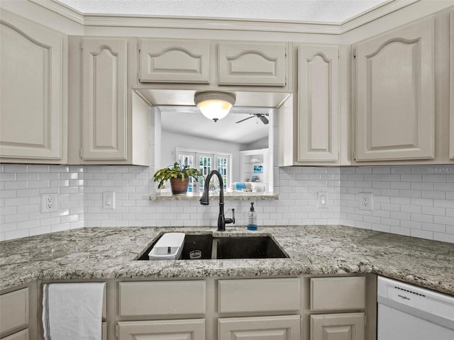 kitchen with tasteful backsplash, dishwasher, ceiling fan, light stone counters, and a sink