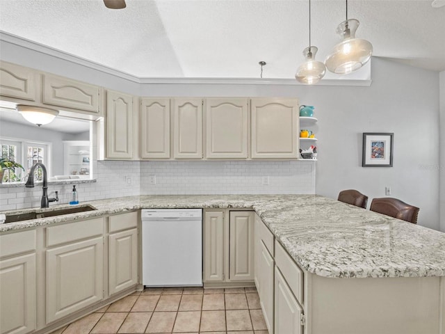 kitchen with light tile patterned floors, tasteful backsplash, a peninsula, white dishwasher, and a sink