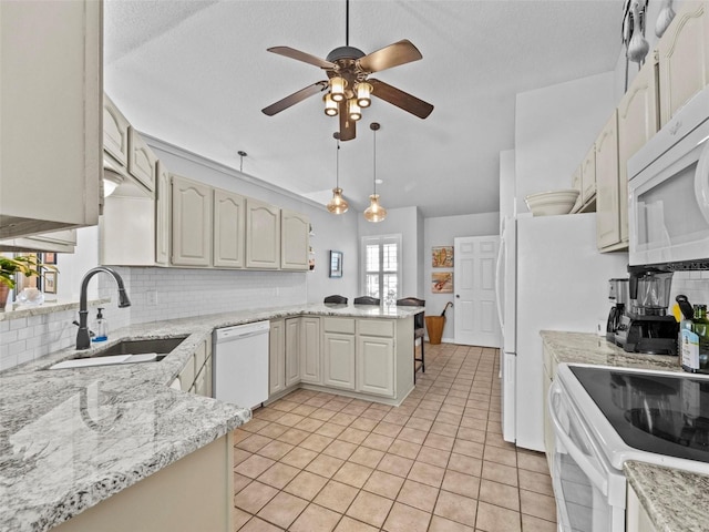 kitchen with a peninsula, white appliances, backsplash, and a sink