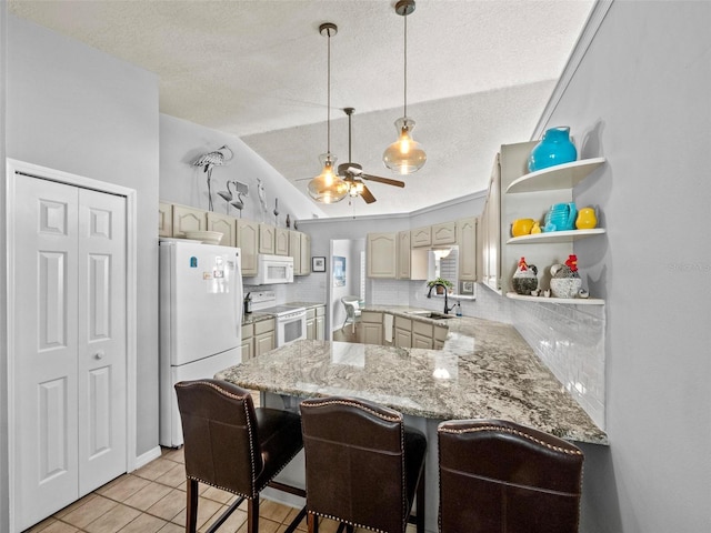 kitchen featuring ceiling fan, a peninsula, white appliances, a sink, and backsplash