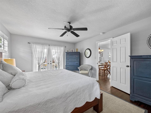 bedroom with access to exterior, dark wood-style flooring, and multiple windows