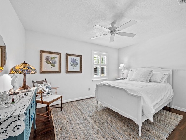 bedroom with dark wood-type flooring, ceiling fan, a textured ceiling, and baseboards