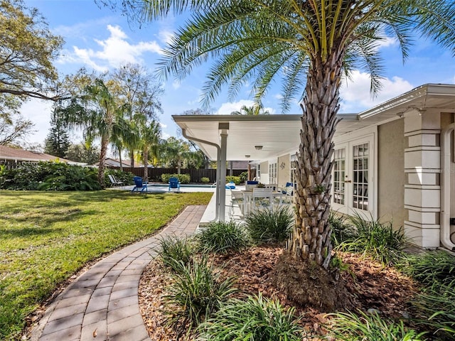 view of home's community with a lawn and fence