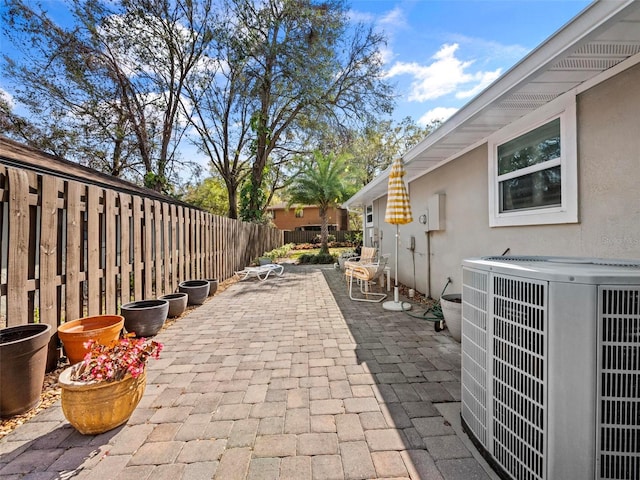 view of patio with a fenced backyard and central air condition unit