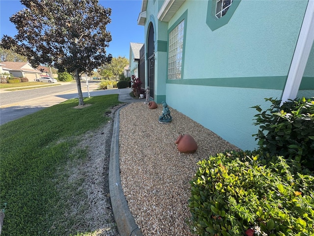 exterior space featuring a yard, a residential view, and stucco siding