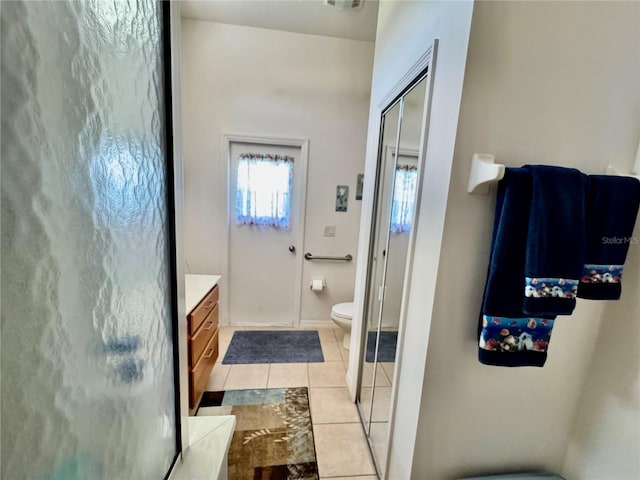 full bath with tile patterned flooring, a stall shower, toilet, and vanity