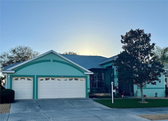 single story home featuring a garage, stucco siding, concrete driveway, and a lawn