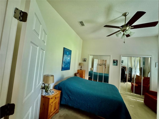 bedroom with visible vents, two closets, and ceiling fan