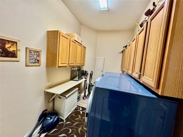 washroom with cabinet space, independent washer and dryer, and a textured ceiling