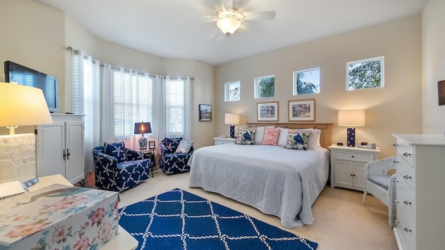 bedroom with light carpet and a ceiling fan